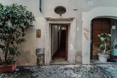 an open door to a building with a plant at La Maisonette di Trastevere in Rome