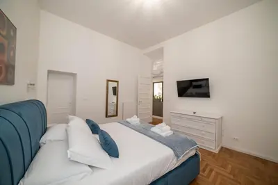 a bedroom with a large white bed with blue pillows at Campo De Fiori Home in Rome