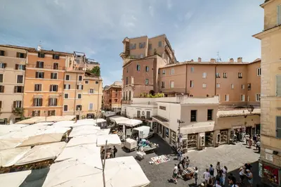 a group of people walking around a city with buildings at Campo De Fiori Home in Rome