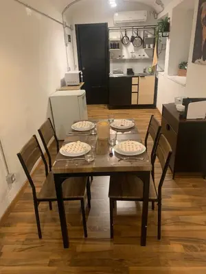 a dining room table with four chairs and a kitchen at DOMUS LAURA Rione MONTI in Rome