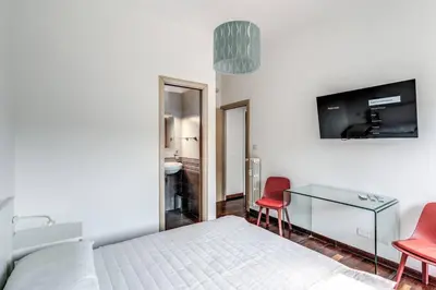 a bedroom with a bed and two red chairs at Re di Roma Lovely Apartments in Rome
