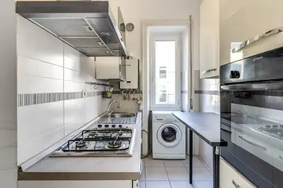 a kitchen with a stove and a washing machine at Re di Roma Lovely Apartments in Rome