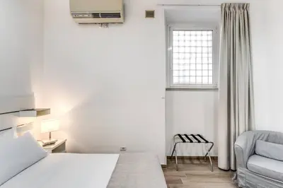 a bedroom with a bed and a chair and a window at New flat in front StPeter Square in Rome