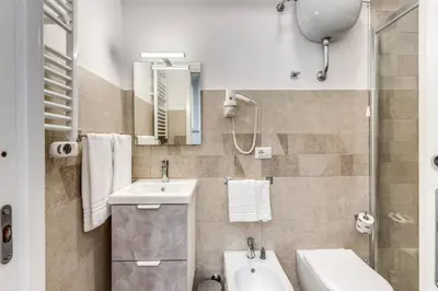 a bathroom with a sink and a toilet and a mirror at New flat in front StPeter Square in Rome