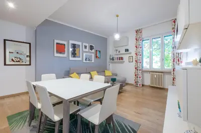 a dining room and living room with a white table and chairs at [CASA LUCIA 5 stelle] Lungotevere della Vittoria in Rome
