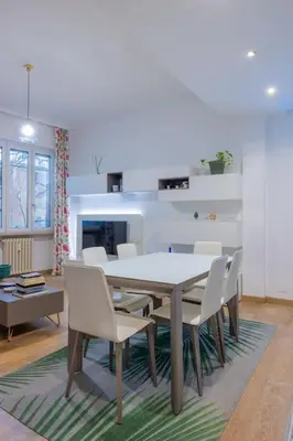 a dining room with a table and white chairs at [CASA LUCIA 5 stelle] Lungotevere della Vittoria in Rome