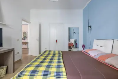 a bedroom with a bed with a yellow and blue blanket at [CASA LUCIA 5 stelle] Lungotevere della Vittoria in Rome