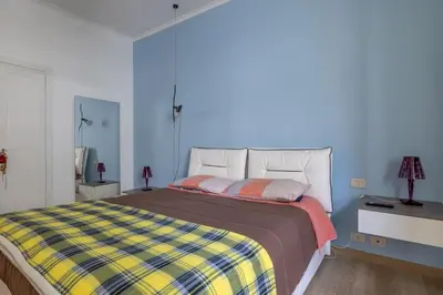 a bedroom with a bed with a checkered blanket at [CASA LUCIA 5 stelle] Lungotevere della Vittoria in Rome