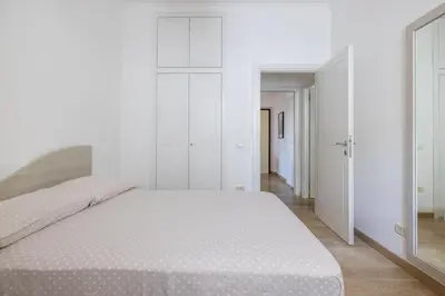 a white bedroom with a large bed and white walls at [CASA LUCIA 5 stelle] Lungotevere della Vittoria in Rome