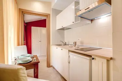 a kitchen with white cabinets and a sink and a table at Top Floor Navona in Rome