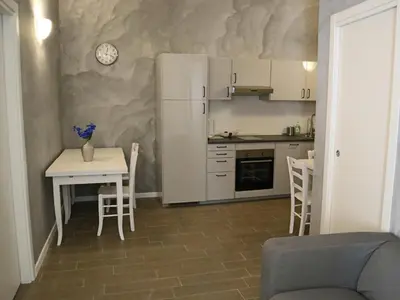 a small kitchen with a table and a white refrigerator at Top Floor Navona in Rome