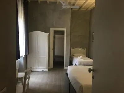 a small room with two beds and a room with a mirror at Top Floor Navona in Rome