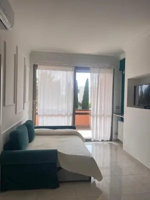 a bedroom with a large bed and a large window at GREEN HOUSE - PARCO TIRRENO by Ohana in Rome
