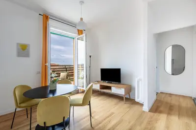 a living room with a table and chairs and a television at Casa Vespi by Hili in Rome