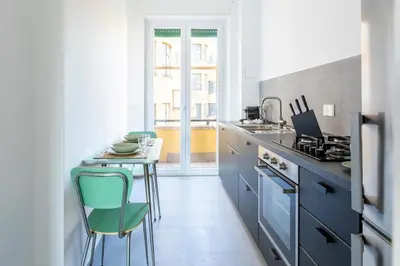 a kitchen with blue cabinets and a table and chairs at Casa Vespi by Hili in Rome