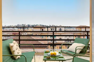 a balcony with chairs and a table with fruit on it at Casa Vespi by Hili in Rome