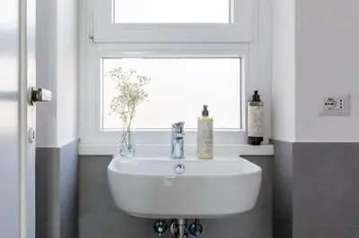 a white sink in a bathroom with a window at Casa Vespi by Hili in Rome