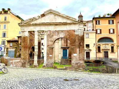 an old brick building with a blue door on a street at Vacanze Romane al Portico d'Ottavia in Rome