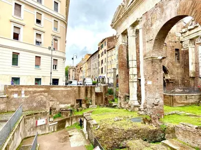 an old building with an arch in a city at Vacanze Romane al Portico d'Ottavia in Rome