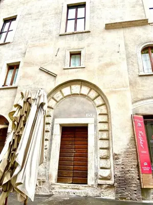 a building with a wooden door and an archway at Vacanze Romane al Portico d'Ottavia in Rome