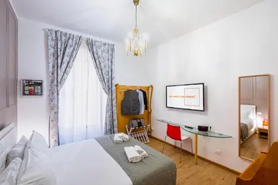 a bedroom with a bed and a desk and a window at The Space Rooms in Rome
