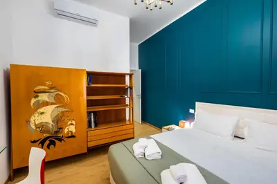 a bedroom with a bed and a blue wall at The Space Rooms in Rome