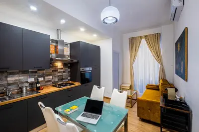 a kitchen with a table with a laptop on it at The Space Rooms in Rome