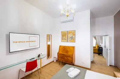 a living room with white walls and a chandelier at The Space Rooms in Rome