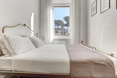 a white bed in a white bedroom with a window at Home and More St. Angelo APT 5 in Rome