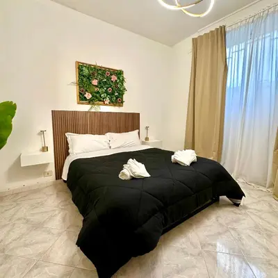 a bedroom with a black bed with two towels on it at Golden Luxury Home - San Giovanni - 3 min to Colosseum in Rome