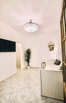 a white room with a potted plant on the floor at Golden Luxury Home - San Giovanni - 3 min to Colosseum in Rome
