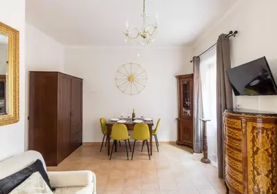 a living room with a table and yellow chairs at Navona Home in Rome
