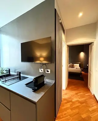a kitchen with a counter and a room with a bed at Sopi Vatican Suite Apartment in Rome