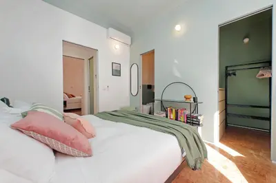 a bedroom with a white bed with pink pillows at YCH-Lussuoso appartamento al Colosseo in Rome