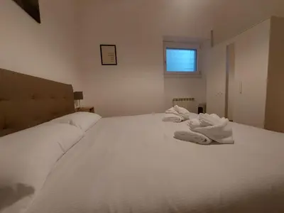 a white bed with towels on it in a bedroom at VATICAN PITTORE HOUSE in Rome