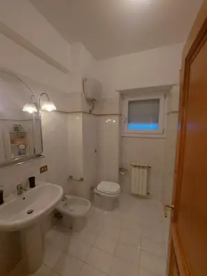 a white bathroom with a sink and a toilet at VATICAN PITTORE HOUSE in Rome