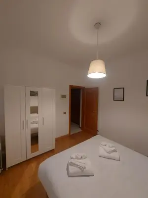 a bedroom with a white bed and a light at VATICAN PITTORE HOUSE in Rome