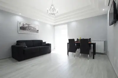 a living room with a black couch and a table at Suite Noir St Peter View in Rome