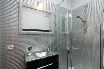 a bathroom with a sink and a shower with a mirror at Suite Noir St Peter View in Rome