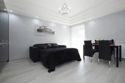 a bedroom with a bed and a table with chairs at Suite Noir St Peter View in Rome