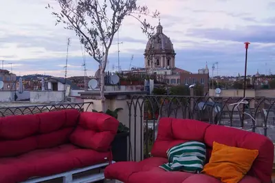 a red couch sitting on a balcony with a building at ROME FOR TWO Campo de' Fiori - your home in Rome in Rome