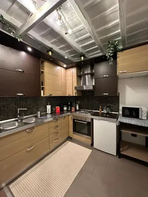 a large kitchen with wooden cabinets and stainless steel appliances at Trithome Suite Boutique Barberini in Rome