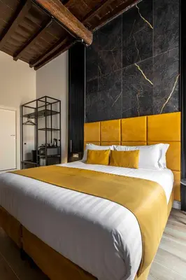 a bedroom with a large bed with a yellow and white blanket at Home at Rome Luxury Navona Guest House 2 in Rome