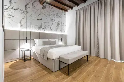 a bedroom with a bed and a marble wall at Home at Rome Luxury Navona Guest House 2 in Rome