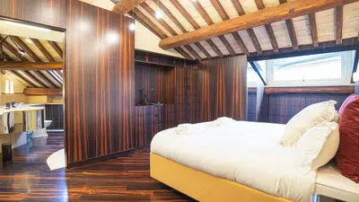 a bedroom with a white bed and wooden walls at EasyTopStay - Piazza Venezia City View Charming Apt in Rome