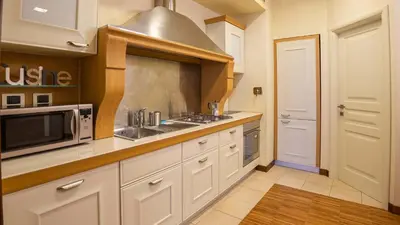 a kitchen with white cabinets and a sink and a microwave at EasyTopStay - Piazza Venezia City View Charming Apt in Rome