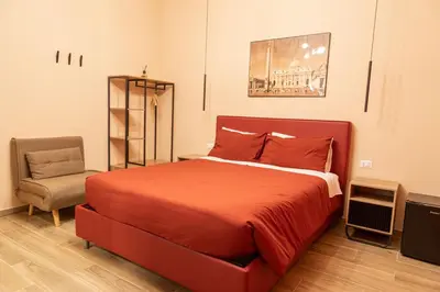 a bedroom with a red bed and a chair at Diamond Vatican Apartment in Rome