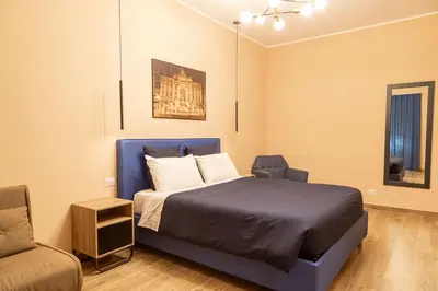 a bedroom with a blue bed and a chair at Diamond Vatican Apartment in Rome