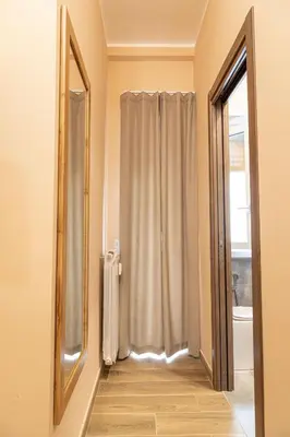 a bathroom with a shower curtain and a mirror at Diamond Vatican Apartment in Rome