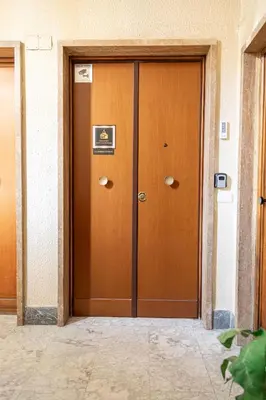 a wooden door in a building with a sign on it at Diamond Vatican Apartment in Rome